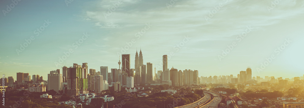 Fototapeta premium Dramatic scenery of elevated highway heading towards Kuala Lumpur city centre during sunset.