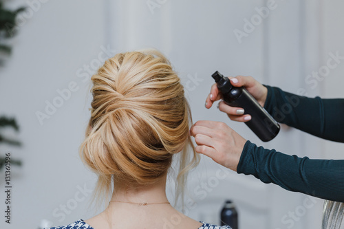 Master stylist makes the bride wedding hairstyle using spray lac