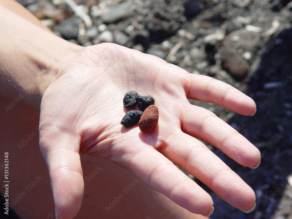 Beach rocks in hand near Exo Gialoso beach in Santorini Beach rocks in hand near Exo Gialoso beach in Santorini