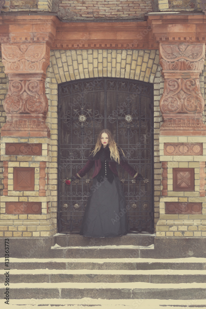 Naklejka premium a beautiful girl standing at the lattice wrought