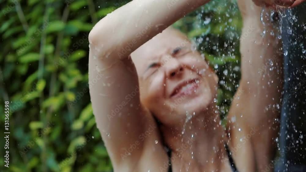 Funny happy woman taking spa shower outdoor in exotic garden. Funny happy woman taking spa shower outdoor in exotic garden.