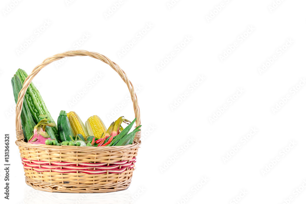 Vegetables and fruits in wicker basket isolated on white background.

