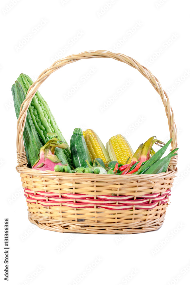 Vegetables and fruits in wicker basket isolated on white background.

