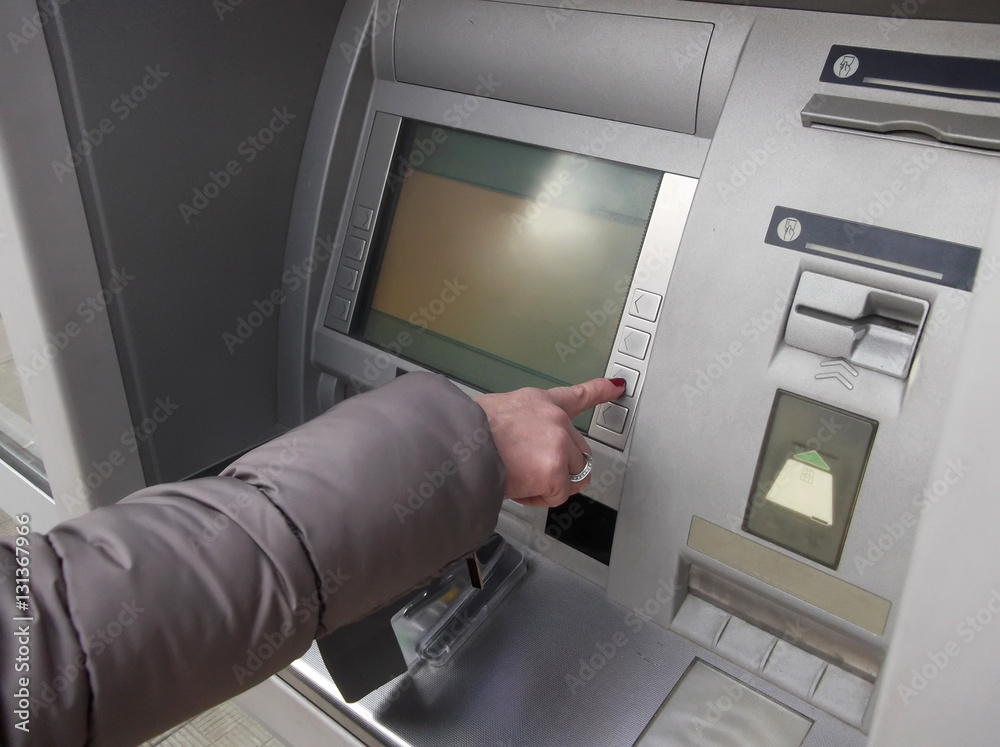 Close up of hand entering pin at an ATM. Woman using banking machine. Close up of hand entering pin at an ATM. Woman using banking machine.