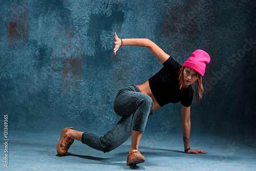 Young girl break dancing on wall background. © master1305
