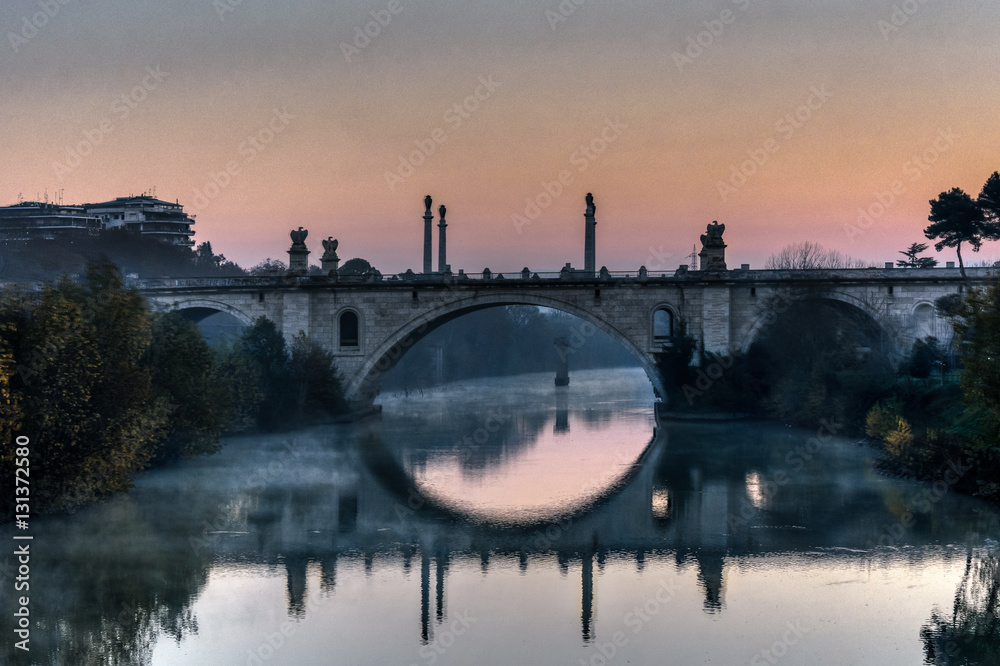 Fototapeta premium Ponte Flaminio reflecting on the Tiber River at sunrise
