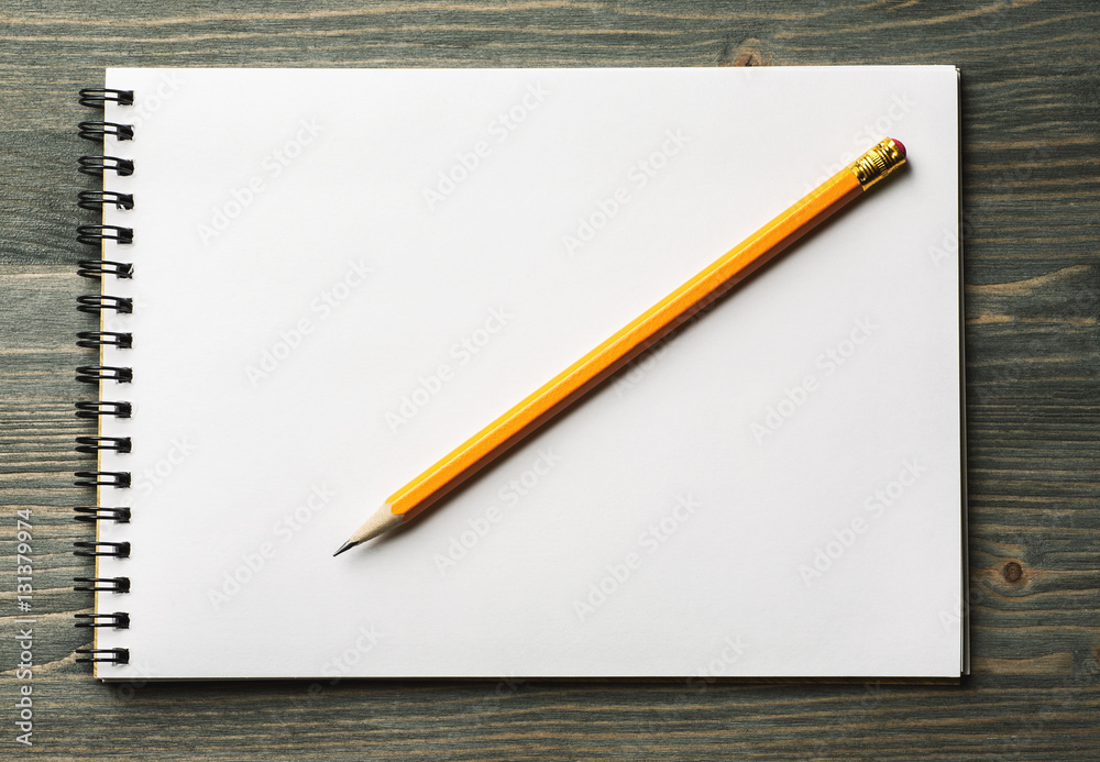White notepad with pencil on it overhead view White notepad with pencil on it overhead view