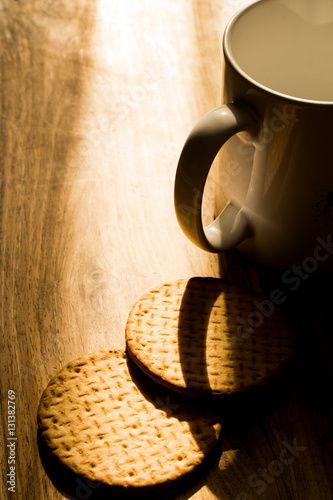 Cup and biscuits on a wooden background. Close up picture. Natural daylight. 