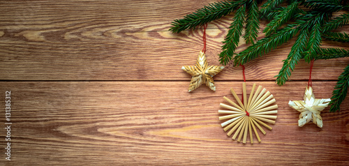 Christmas wooden background with branches of fir tree and straw decorations   empty space.
