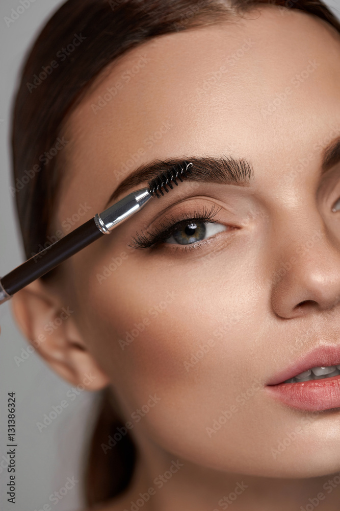Beautiful Woman Brushing Eyebrows With Brush. Beauty