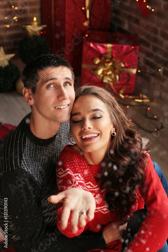 Christmas photo of beautiful tender couple  in cozy clothes celebrating New Year holidays