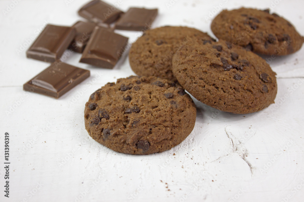 Chocolate biscuits with milk chocolate on white wood Chocolate biscuits with milk chocolate on white wood