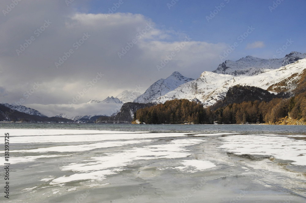 Engadin valley in Switzerland Sils Maria village with snow on Alp mountains and frozen lake