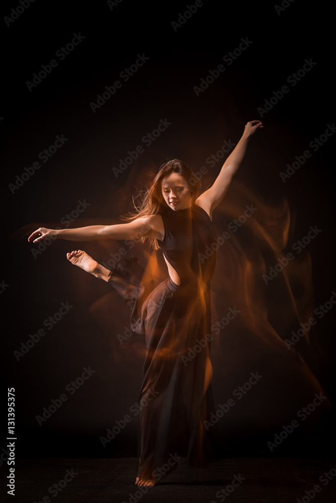Young beautiful dancer on black background