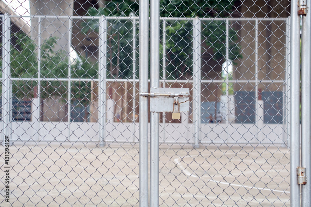 Naklejka premium Padlock / View of padlock on steel mesh door.