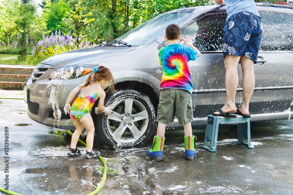 Family car wash Brother & sister help Dad with washing a car in the