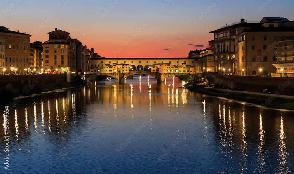 Ponte Vecchio - the oldest bridge of the city of Florence. River Arno, sunset, Tuscany, Italy, the reflection in the water.