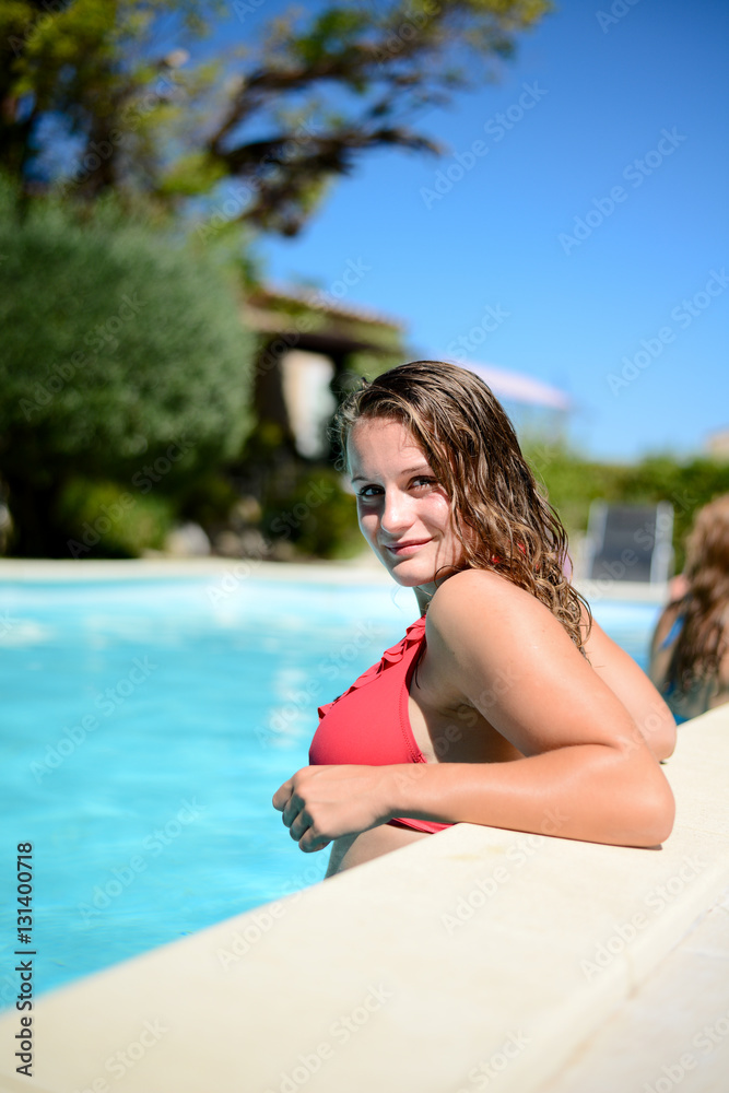 portrait of beautiful young woman in the poolside of a resort swimming pool during summer holiday portrait of beautiful young woman in the poolside of a resort swimming pool during summer holiday