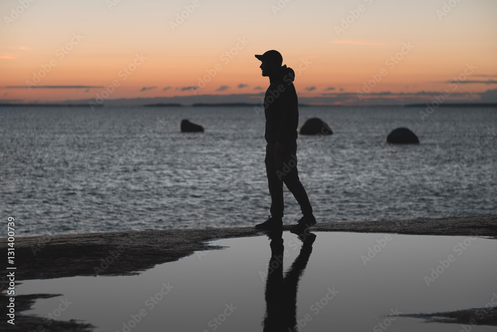 man walking along the shore