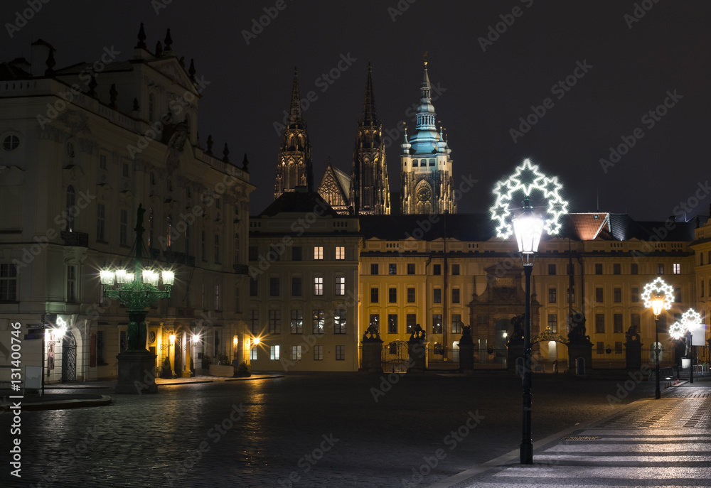 Prague, Czech Republic / Czechia - Hradcany square during night. Prague castle and Saint Vitus Cathedral in the background. Lamp with christmas decoration during winter season