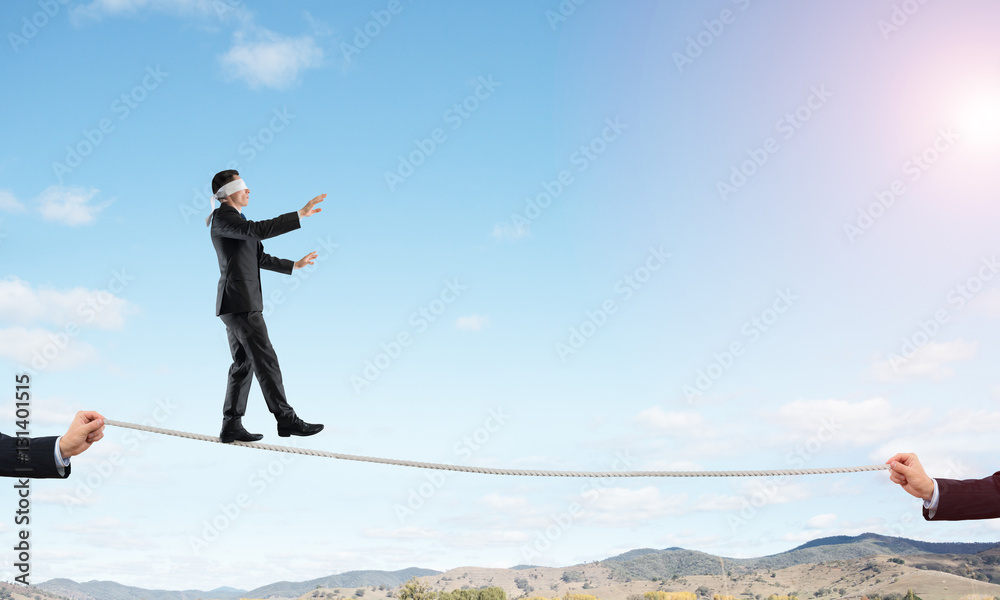 Obraz premium Business concept of risk support and assistance with man balancing on rope