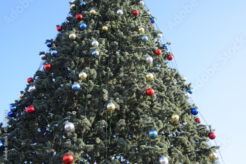 Decorations New Year tree. Tinsel and toys, balls and other decorations on the Christmas Christmas tree standing in the open air