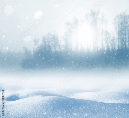 Winter background with deep snowdrifts and trees in the fog