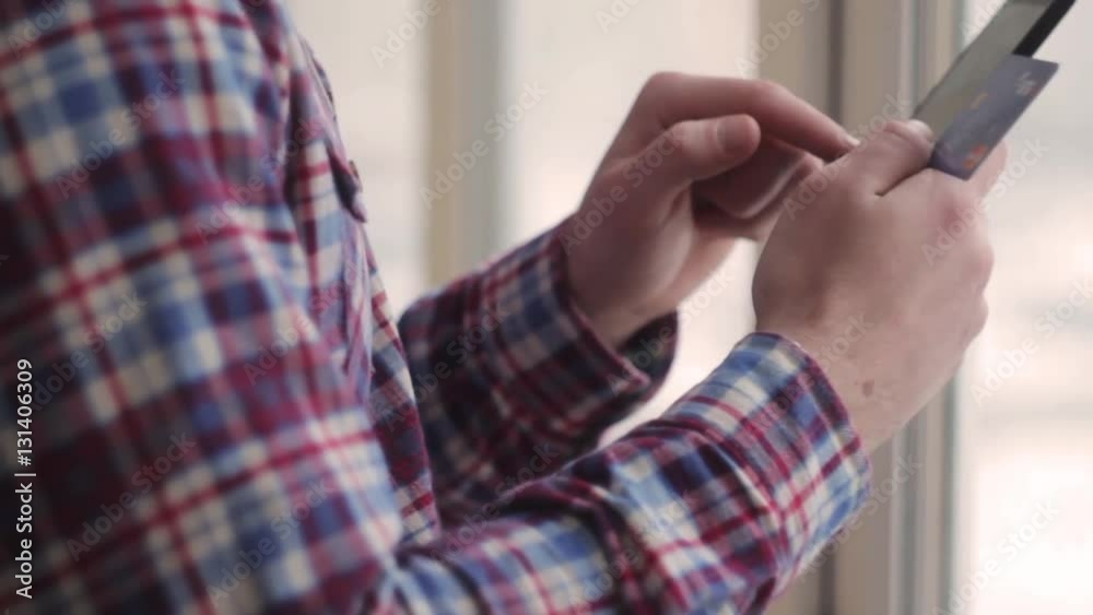 Young man online banking using smartphone shopping online with credit card at home lifestyle Young man online banking using smartphone shopping online with credit card at home lifestyle
