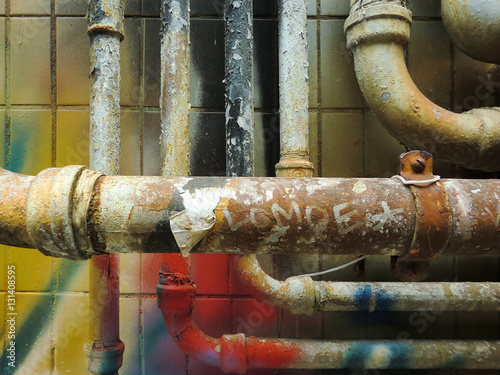 Urban ghetto pipe plumbing against grungy wall texture