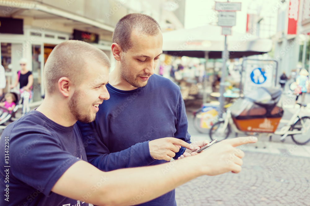 Young handsome men searching for right direction on smartphone m Young handsome men searching for right direction on smartphone m