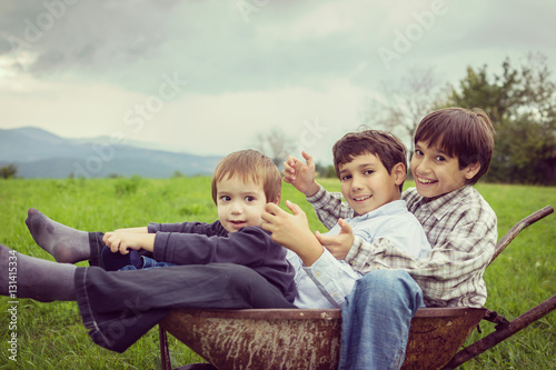 Happy kids on field playing with cart