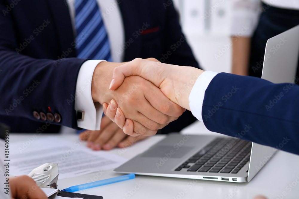 Business handshake at meeting or negotiation in the office. Partners are satisfied because signing contract or financial papers Business handshake at meeting or negotiation in the office. Partners are satisfied because signing contract or financial papers