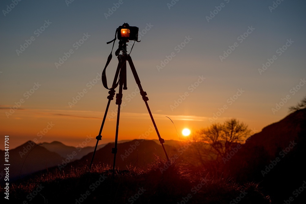 camera mounted on a tripod to photograph the sunset camera mounted on a tripod to photograph the sunset