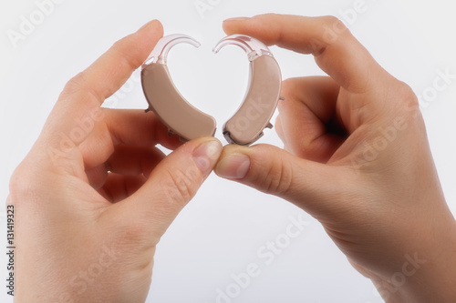 Tableau sur toile Hands forming a heart shape from hearing aids