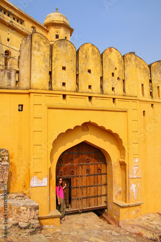 Young woman standing by the gate in Amber Fort near Jaipur, Raja