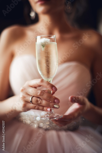 Beautiful woman, bride holding glass of champagne. Christmas and New Year holiday celebration