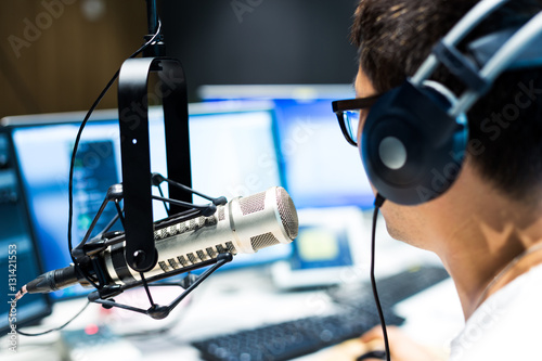 young man dj works in modern broadcast studio