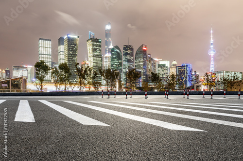 Asphalt road and modern cityscape at night in Shanghai