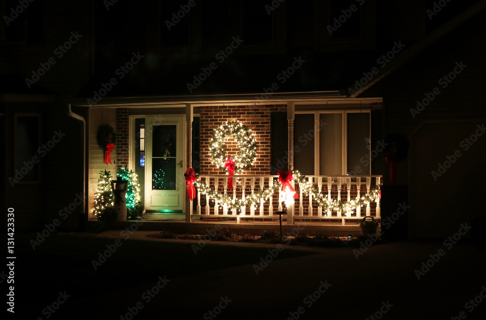 Seasonal house outdoor decorations. Porch decorated for seasonal winter holidays plowing in the dark. Christmas and New Year background. Night scene.
