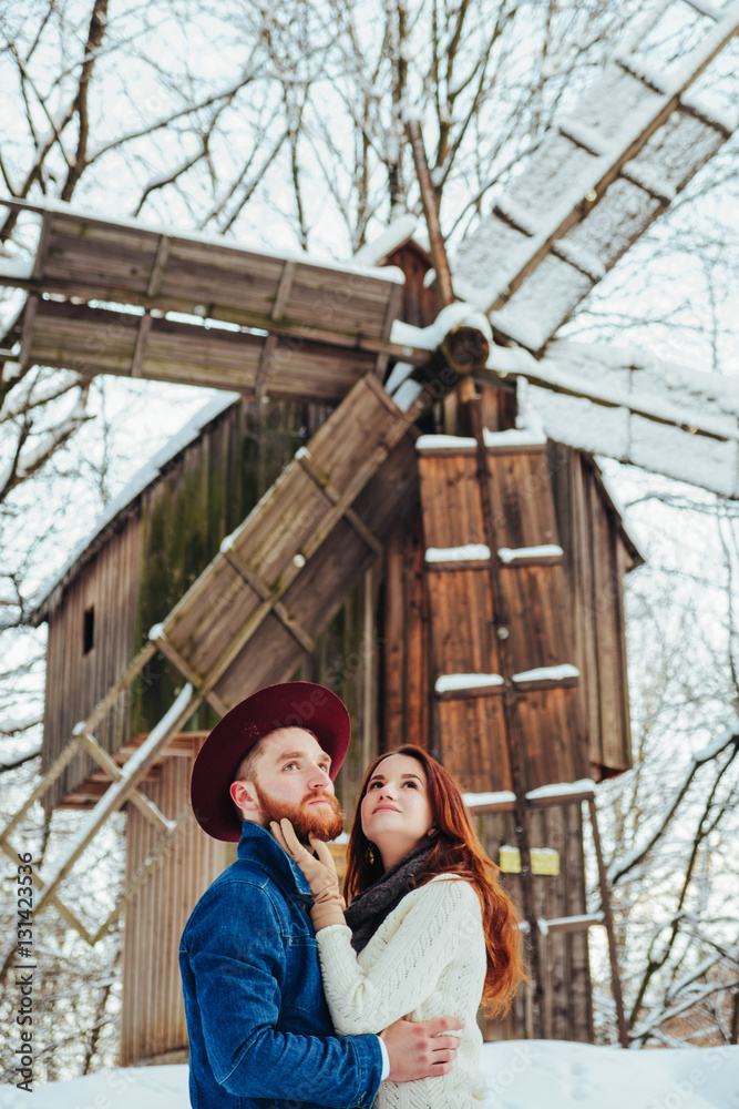 loving and beautiful couple standing together near a large mill loving and beautiful couple standing together near a large mill