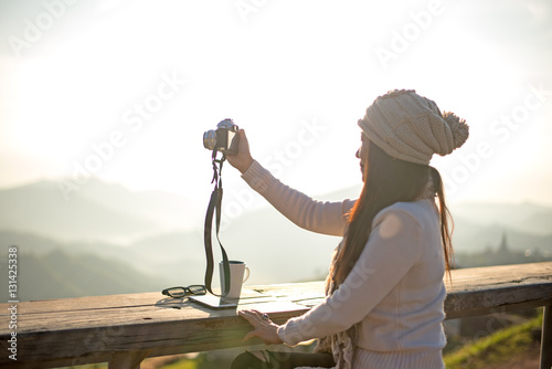 Woman drinking coffee in sun sitting outdoor in sunshine light enjoying her morning coffee, vintage, soft and select focus.