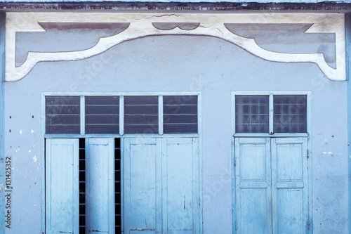Blue wooden window on blue cement wall. Vintage color.