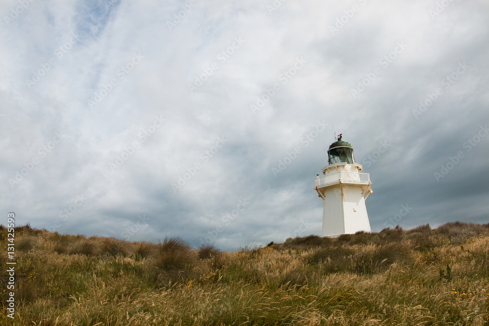 Waipapa Point lighthouse with background of cloudy sky Waipapa Point lighthouse with background of cloudy sky