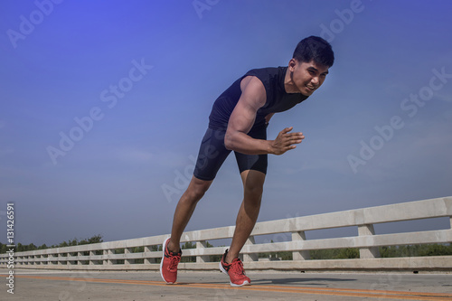 Man running sprinting on road. Fit male fitness runner during ou