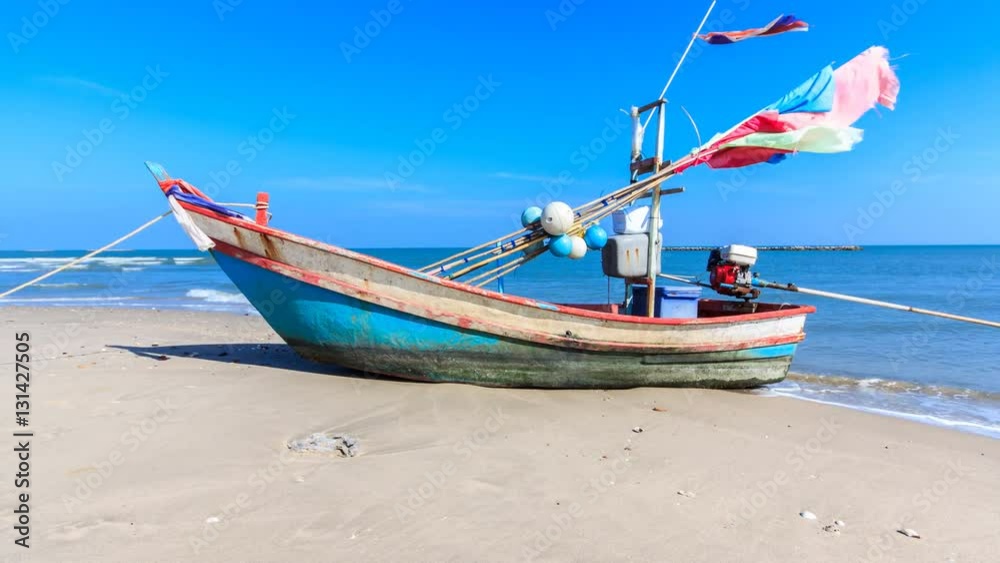 the alone fishing boat on the beach with blue sky in Thailand ocean the alone fishing boat on the beach with blue sky in Thailand ocean