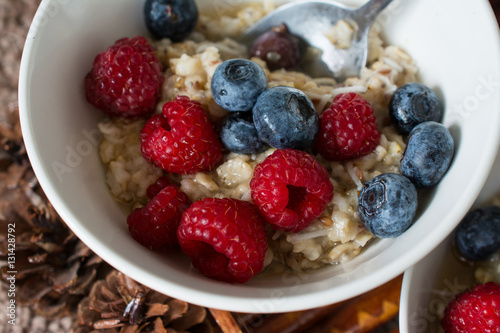 Oatmeal with berries in a bowl. Rasberries and blueberries. Flax seeds