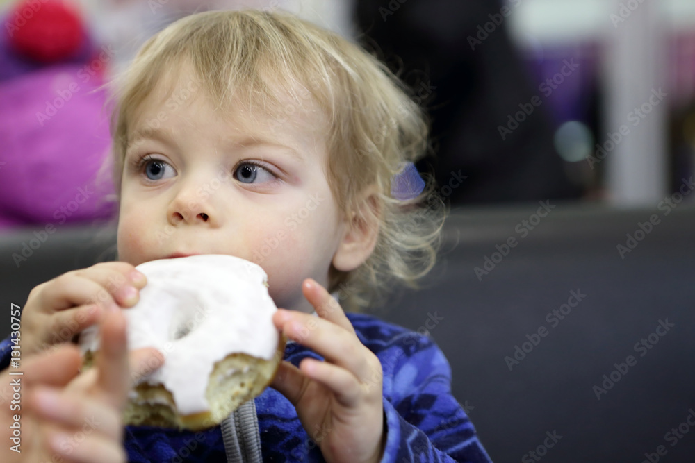 Child biting donut Child biting donut