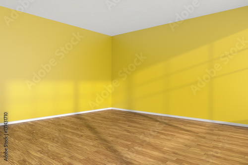 Empty room corner with yellow walls and wooden parquet floor