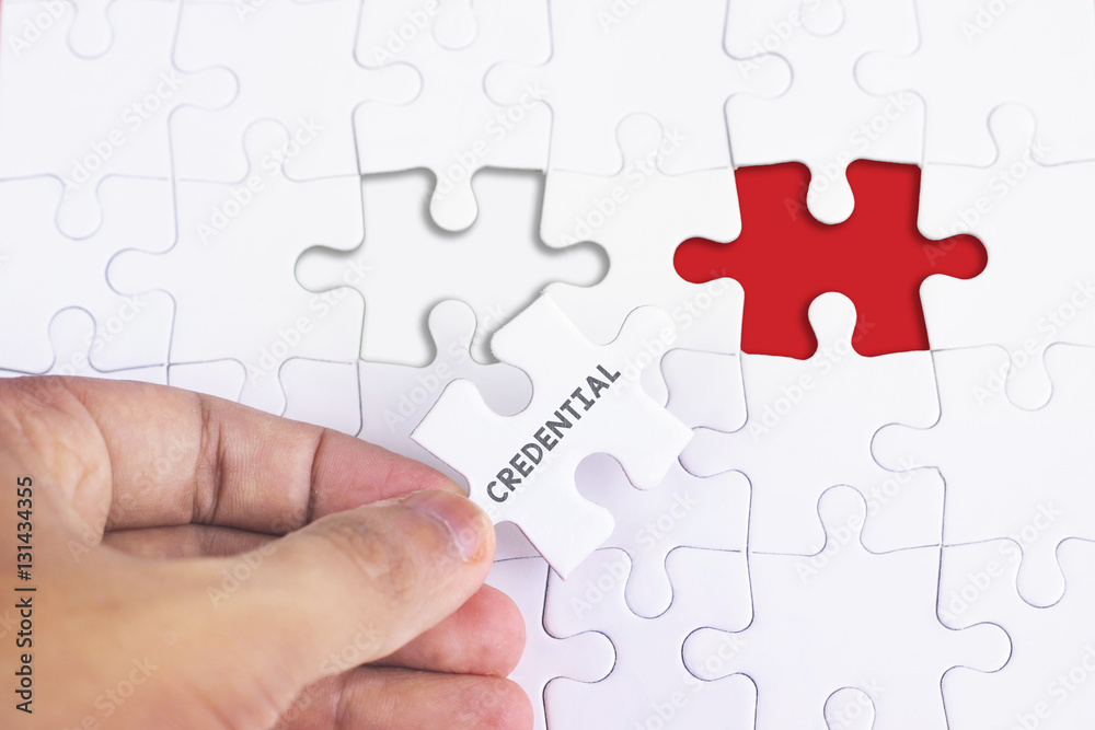 Business Concept - Female hand and missing puzzle with CREDENTIAL Business Concept - Female hand and missing puzzle with CREDENTIAL