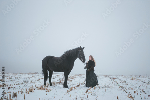 a girl with a horse in a field in winter © makam1969